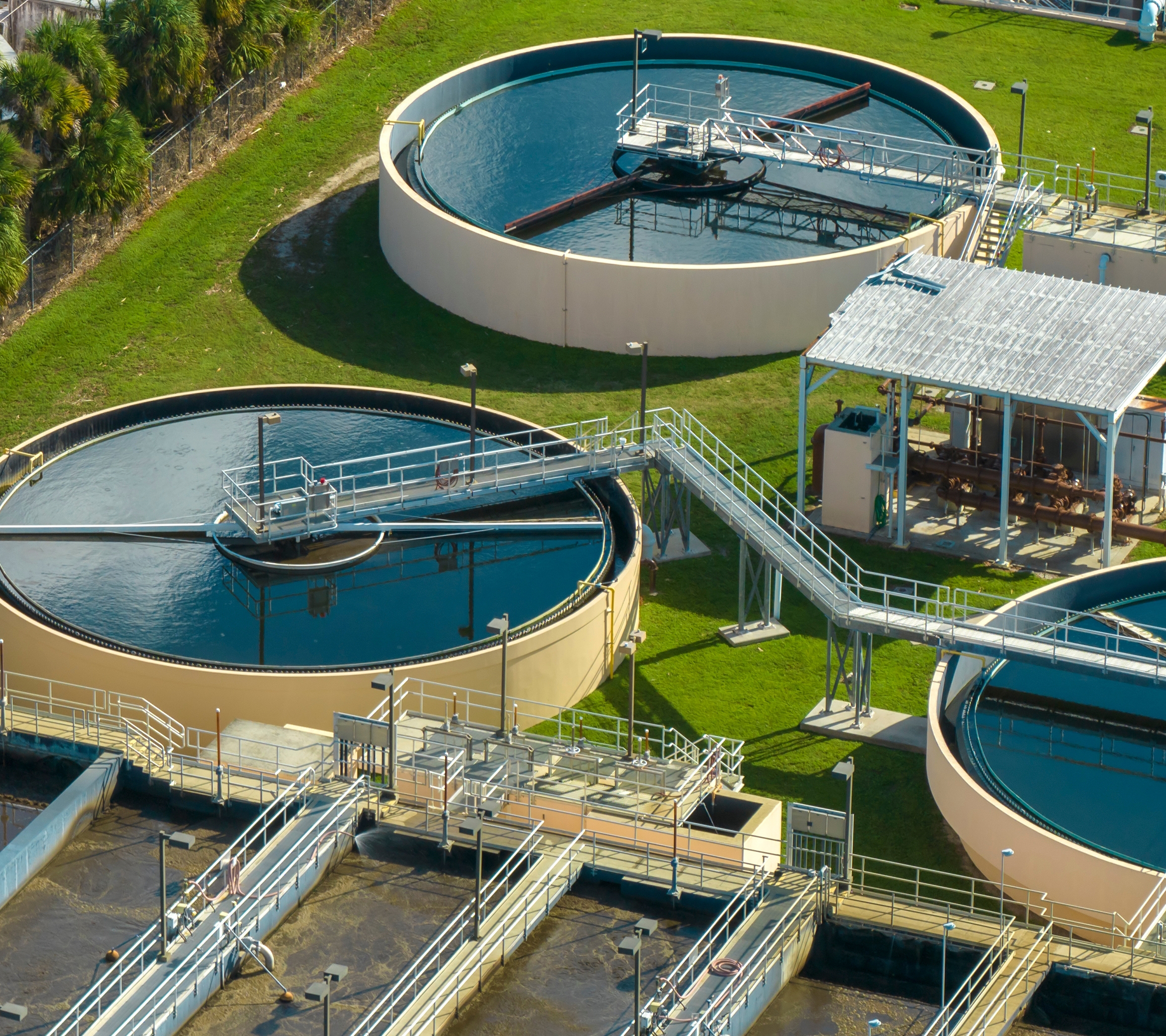 Aerial view of a water treatment plant with large tanks and pipelines.