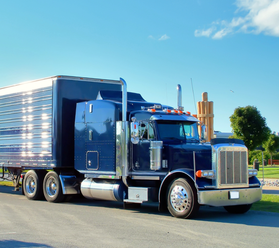 Heavy-duty blue commercial truck and trailer on transport route