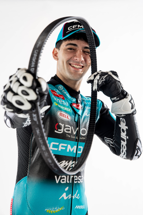 Smiling motorcycle racer posing with a Gates drive belt