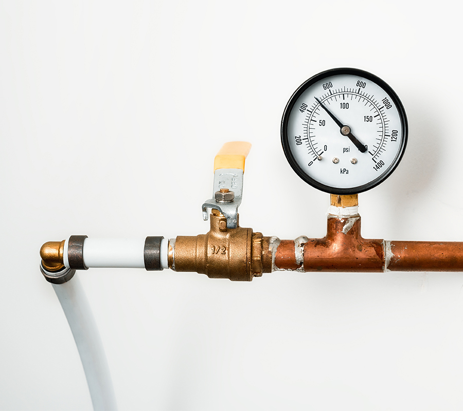 image of copper plumbing attached to a white wall