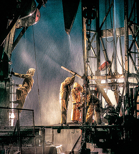 Oil workers drilling on a site in the rain