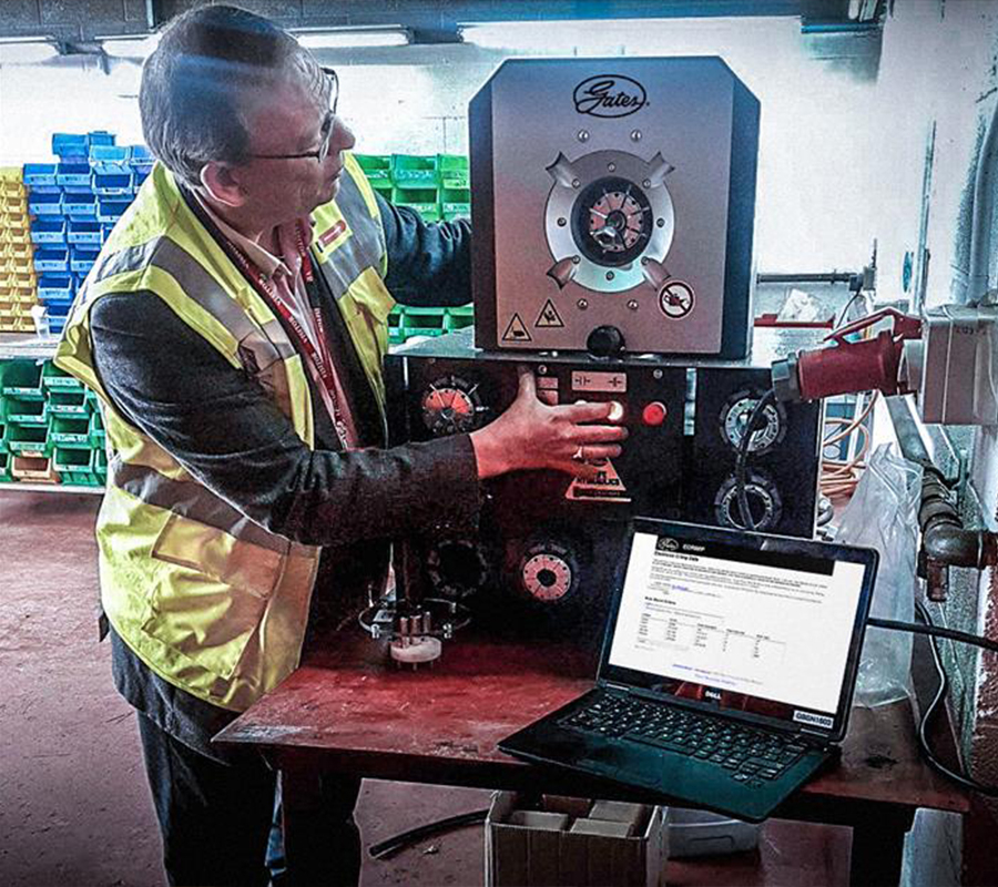 man in safety vest stands next to Gates® crimper and eCrimp™ online platform