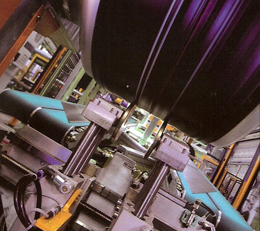 Full color image of a second stage tire manufacturing machine using Gates® TPU belts