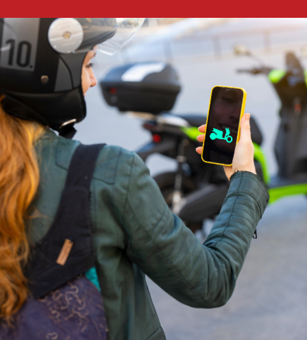 Woman connecting an electric motorcycle with the smartphone