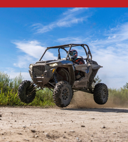 UTV catching air on a dirt trail, showcasing off-road power and suspension in action