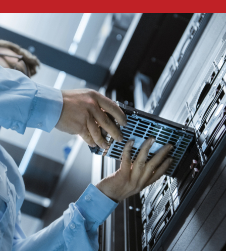 Technician installing a hard drive into a server rack in a data center