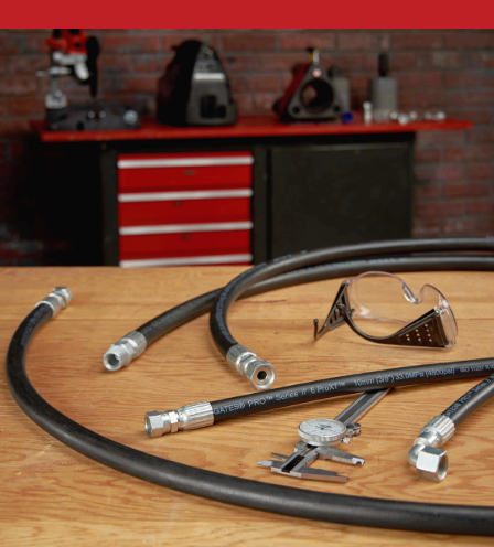 A collection of tools and a hose on a wooden table.
