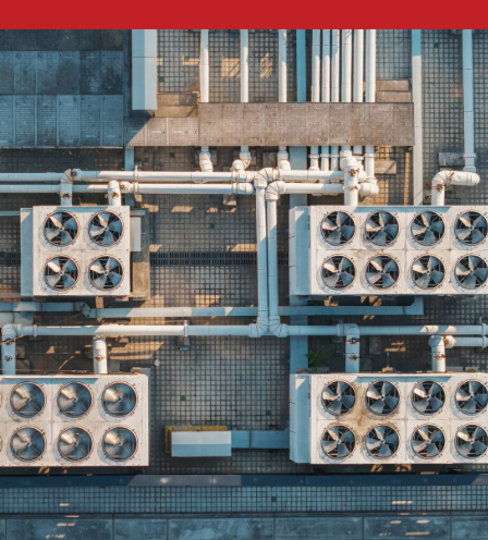 Aerial view of rooftop HVAC units with circular fans and white piping arranged in a clean geometric grid.