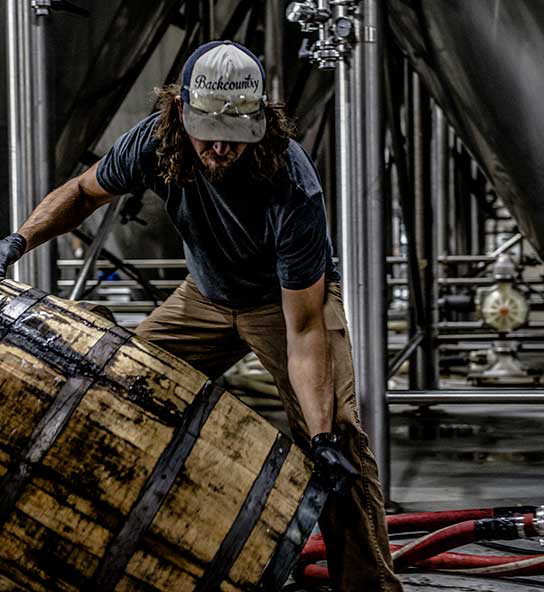 Food and beverage worker moving a barrel