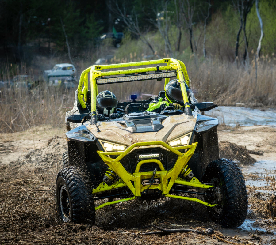 Yellow UTV navigating muddy terrain