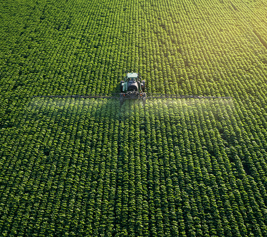 View from above of a tractor spraying a field.