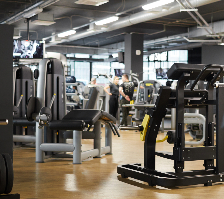 Background image of various exercise machines in workout hall of modern gym interior