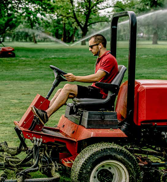 Grounds maintenance worker  on riding lawn mower