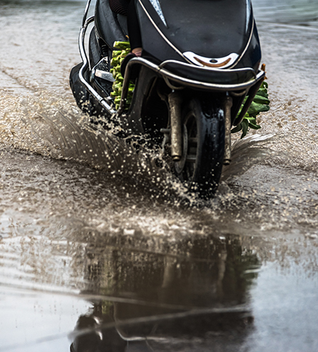 Motor scooter driving through puddles