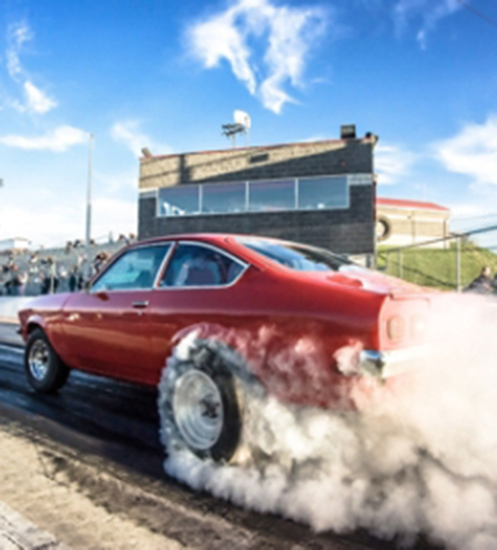 Red car on race track with smoking tires