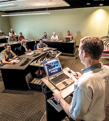 Trainer at podium leading training session