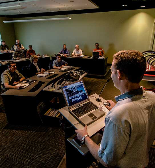 Trainer at podium leading training session