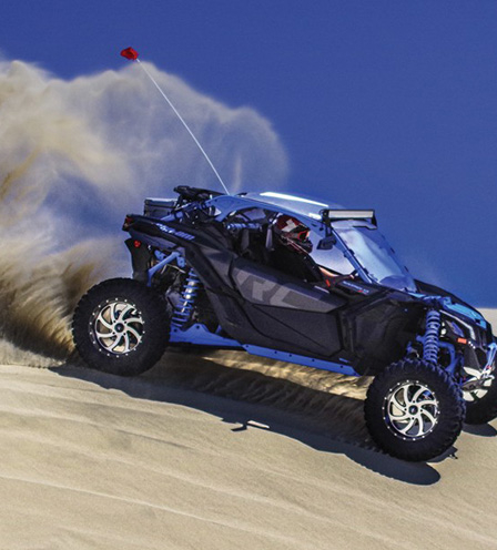 a navy blue buggy riding through a dessert with high speed 