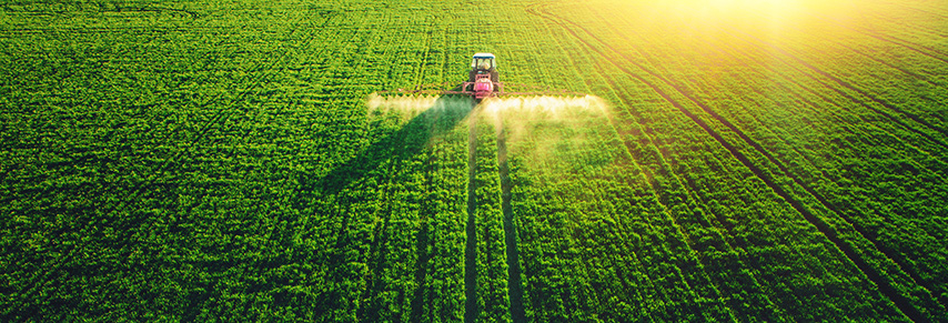 Tractor spraying insecticide on crops