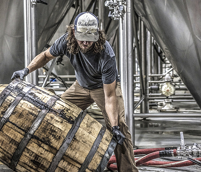 Food and beverage worker moving a barrel