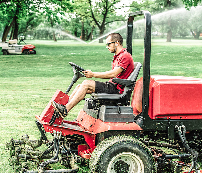 Grounds maintenance worker  on riding lawn mower